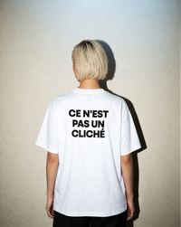 White heavyweight cotton oversized T-shirt with large 'Ce N'ést Pas Un Cliche' graphic slogan printed on both on the front and the back, oversized structured box fit. unisex silhouette and premium streetwear styling.