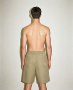 thirdofthefifth pleated breathable cotton shorts in muted earthy tone featuring front pleats, elasticated waistband, relaxed tailored fit, and above-knee silhouette designed for warm-weather dressing. unisex