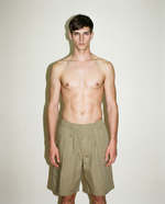 thirdofthefifth pleated breathable cotton shorts in muted earthy tone featuring front pleats, elasticated waistband, relaxed tailored fit, and above-knee silhouette designed for warm-weather dressing. unisex